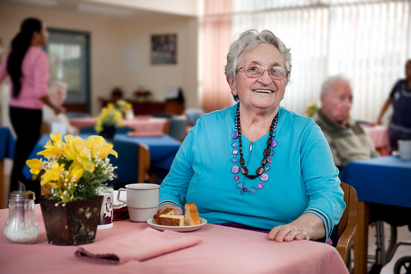Lady eatign bread with flowers at Kalyna Care
