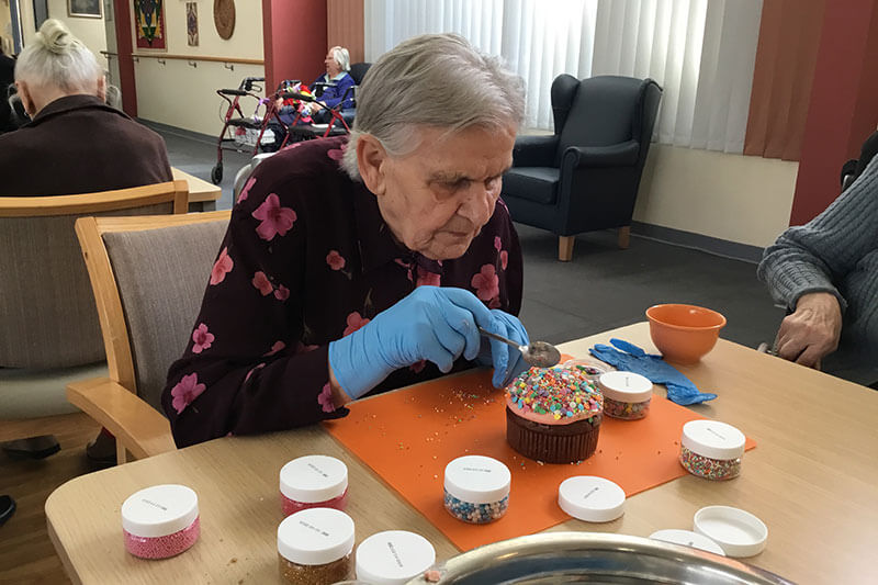 Lady decorating a cupcake at Kalyna Care
