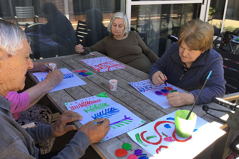 Residents painting outdoors at Kalyna Care